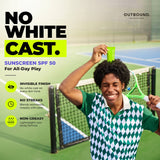 A smiling man on a tennis court holds a green sunscreen tube on his head while wearing an Outbound brand green and white argyle shirt. The left side features text promoting 'NO WHITE CAST.